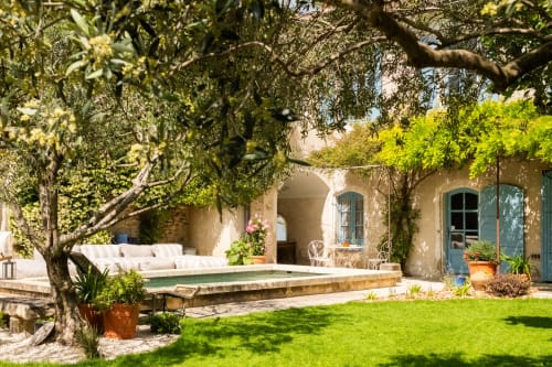 Vue sur la piscine de la Suite le Jasmin au Jardin Secret à Grignan, France, avec jardin luxuriant, olivier et cour méditerranéenne