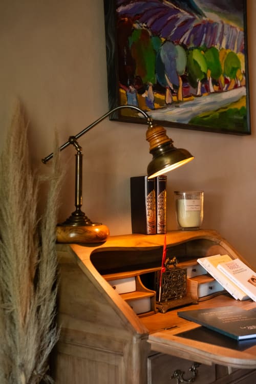 Bureau de la Suite le Jasmin au Jardin Secret à Grignan, avec lampe en laiton, bougie et œuvres colorées