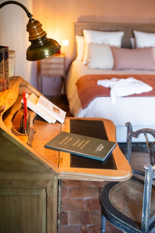 Bureau de chevet au Jardin Secret B&B à Grignan avec lampe en laiton, livres et vue sur la suite