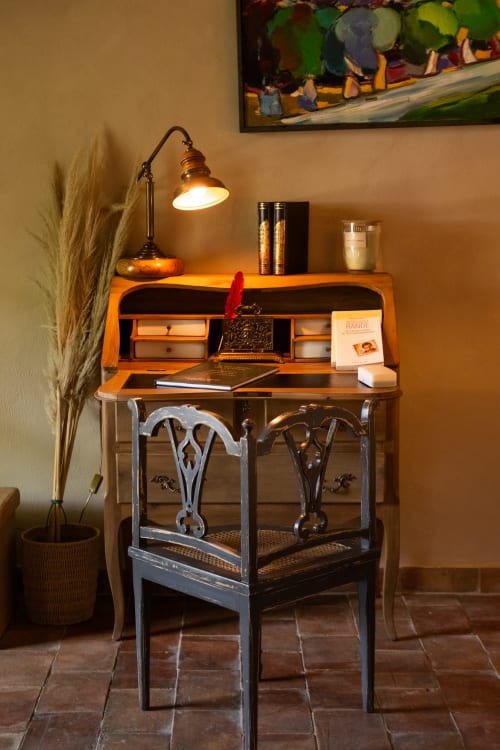 Bureau vintage avec plateau en bois et base métallique ornée dans la Suite le Jasmin au Jardin Secret, Grignan, avec lampe de bureau et