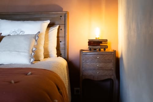Chambre douillette au Le Jardin Secret B&B à Grignan avec lit en bois, oreillers blancs et table de nuit avec lampe