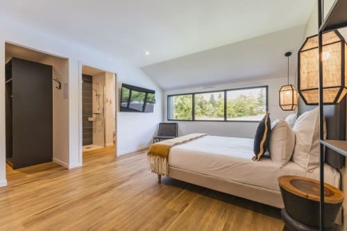 Chambre moderne à La Clairière aux Chênes avec lit queen-size, vue sur le jardin, salle de bain attenante et décoration contemporaine
