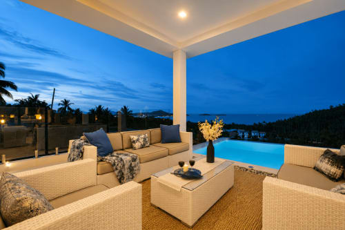 Terrasse luxe au bord de la piscine au crépuscule avec vue mer, salon de détente et piscine illuminée à l'Indigo Villa Samui, Ko Samui Thaïlande