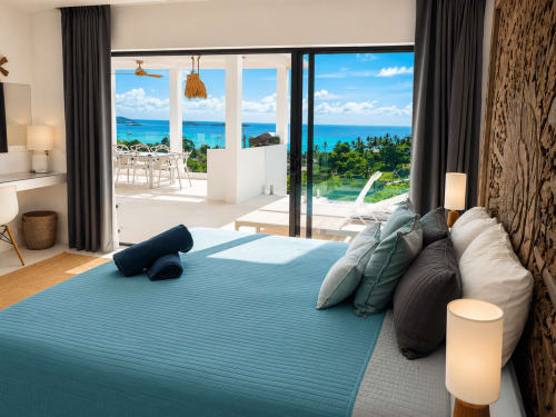 Villa de luxe en bord de mer à Ko Samui, chambre avec vue océan, lit king-size et terrasse privée donnant sur les jardins tropicaux