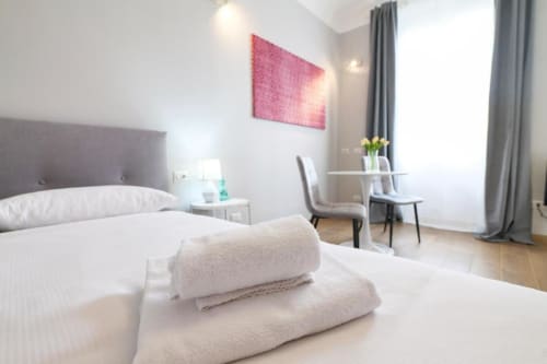 Camera da letto moderna milanese con letti gemelli, arte murale rosa, scrivania e vista giardino presso ACasaDiImma