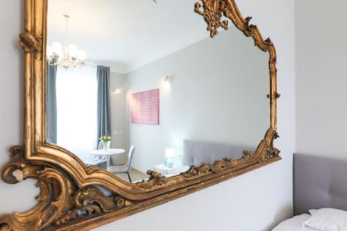 Specchio con cornice dorata ornamentale che riflette la camera da letto dell'appartamento ACasaDiImma Milano, Maison Collection Navigli