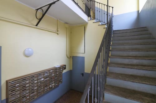 Ingresso della scala di ACasaDiImma Milano con cassette postali e dettagli blu
