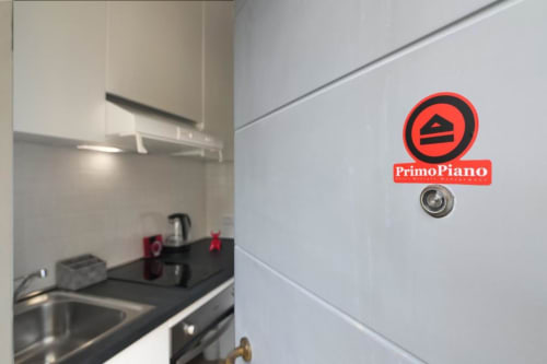Logo PrimoPiano sulla parete della cucina nell'appartamento di Milano dell'hotel ACasaDiImma