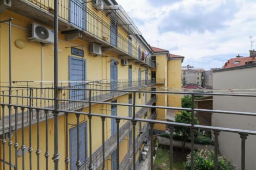 Palazzo giallo con balconate a Milano, con vista sul giardino e ubicato in cortile interno