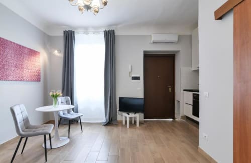 Moderno monolocale a Milano con zona pranzo, TV schermo piatto, parquet e angolo cottura presso ACasaDiImma