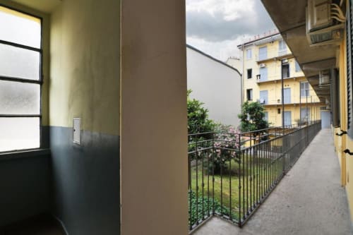 Balcone coperto con ringhiera in metallo con vista sul giardino dell'appartamento ACasaDiImma Milano