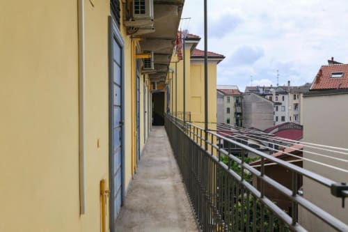 Balcone coperto con facciata gialla e vista sui tetti di Milano, appartamento ACasaDiImma