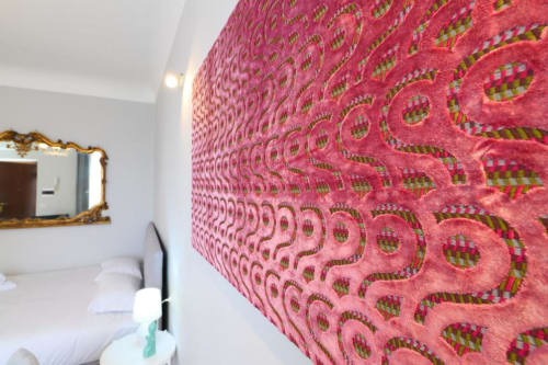 Parete con motivi geometrici rosa acceso in camera da letto di appartamento milanese con pareti bianche e specchio