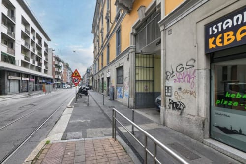 Via storica di Milano con binari del tram, edifici residenziali e kebab vicino all'appartamento ACasaDiImma.