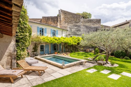 Cour piscine du Jardin Secret à Grignan avec transats, oliviers et murs en pierre