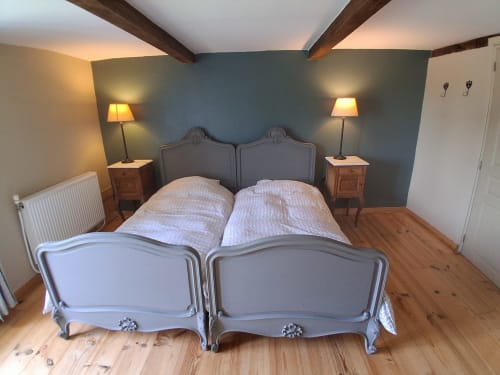 Chambre spacieuse aux Trois Voisins B&B à Bourseigne-Vieille avec lits jumeaux, poutres apparentes et mur d'accent bleu-vert