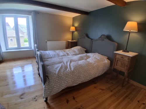 Chambre spacieuse aux Trois Voisins B&B à Bourseigne-Vieille avec lit en bois, murs bleu-vert et lumière naturelle