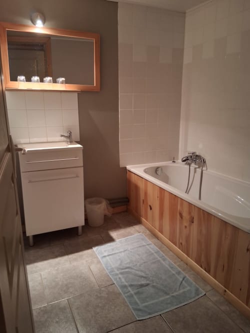 Salle de bain moderne aux Trois Voisins avec baignoire, lavabo et miroir, à Bourseigne-Vieille