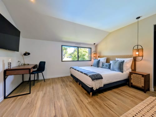 Chambre moderne à La Clairière aux Chênes avec lit queen-size, fenêtres vue jardin, bureau et luminaires suspendus