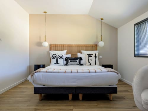Chambre moderne à La Clairière aux Chênes avec luminaires suspendus contemporains, coussins artistiques et bois
