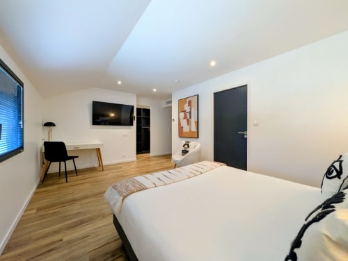 Chambre moderne de la Chambre d'hôtes La Clairière aux Chênes à Treillières avec bureau, TV et salle de bains attenante