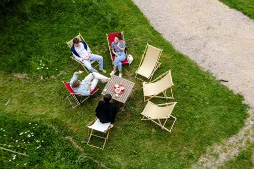 Guests relaxing in deck chairs on green lawn at Château de Vaux Morvan B&B in Étang sur Arroux, France
