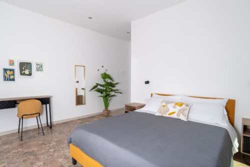 Camera Matrimoniale Superiore a Domo Cadò a Berchidda con vista giardino, arredamento moderno, scrivania e opere d'arte contemporanea
