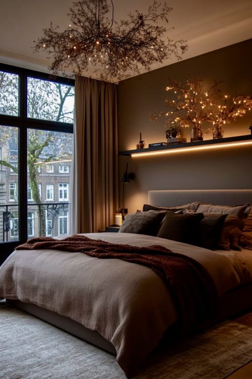 Luxury bedroom in Castres hotel with city view, warm lighting, modern furnishings, and large windows overlooking historic