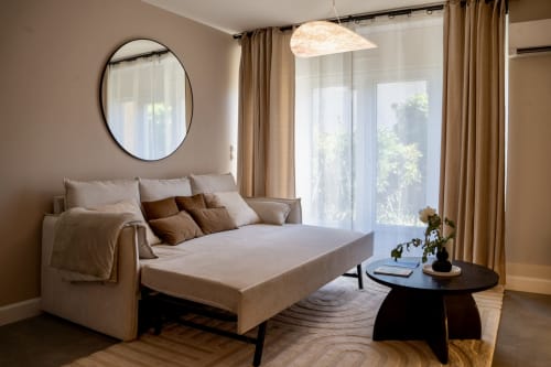 Modern Japandi suite at Le 1 Péraudel in Castres with sleek sofa bed, round mirror, pendant light, and garden views