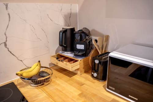 Modern kitchen counter with blender, toaster, fruit basket, and utensils in Le 1 Péraudel Suite apartment, Castres