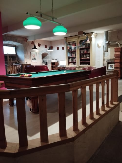 Salle de billard du Domaine De Maleval avec luminaires turquoise et balustrades en bois