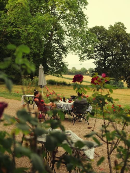 Repas en plein air au jardin du Château de Vaux Morvan B&B à Étang sur Arroux, avec parasol et roses
