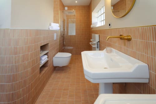 Salle de bains moderne en terre cuite à L'Ode à Pierre B&B à Dax avec lavabo colonne et douche ouverte