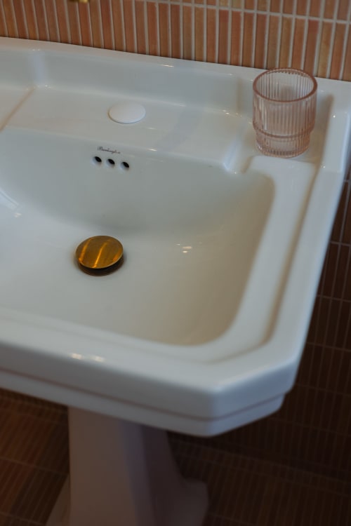 Lavabo blanc à L'Ode à Pierre B&B à Dax avec distributeur de savon ambré et porte-verre rose