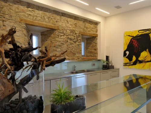 Cucina moderna con muri in pietra nella casa colonica Lodole, arredata con elementi naturali e opere d'arte
