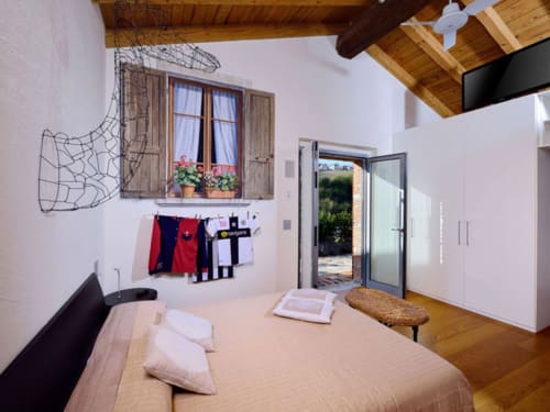 Camera luminosa a Lodole Country House con travi in legno, finestra con vista sul giardino e comfort moderni a Monzuno, Italia