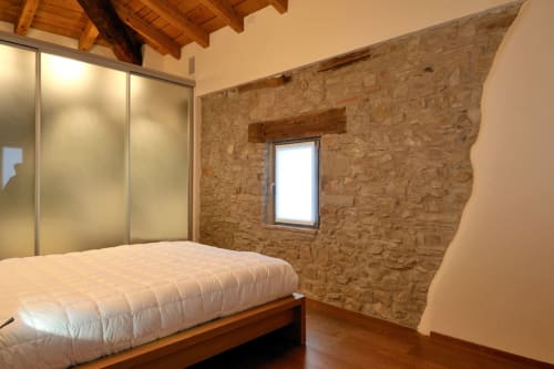 Camera da letto in cottage moderno presso Lodole Country House con parete in sughero, travi in legno, armadio in vetro satinato e vista sul giardino