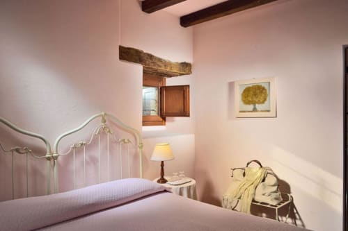 Camera Sunrise Superior presso la Lodole Country House a Monzuno, con letto in ferro battuto, pareti rosa, travi in legno e