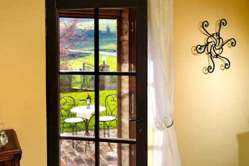 Veduta dei giardini attraverso le porte finestre della Lodole Country House a Monzuno, Italia - Camera Superior con sedie in ferro battuto