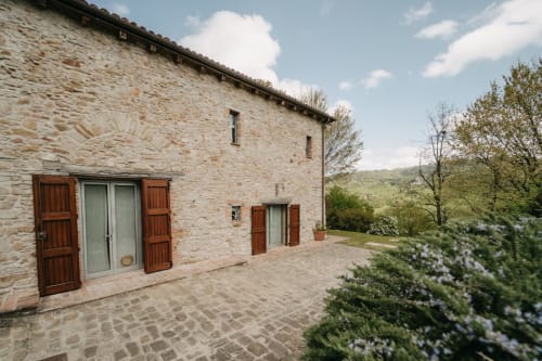 Casa in pietra toscana a Lodole Country House con persiane in terracotta, cortile con giardino e vista sulle colline