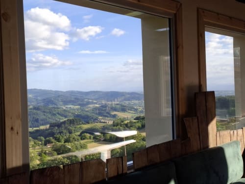 Vue panoramique de la vallée depuis la fenêtre de La Maison de Dun, Saint Racho, montrant les collines ondulantes et le paysage champêtre