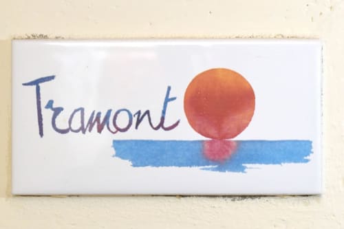 Insegna Tramont con sole arancione e tratto blu presso la Country House Lodole, Monzuno