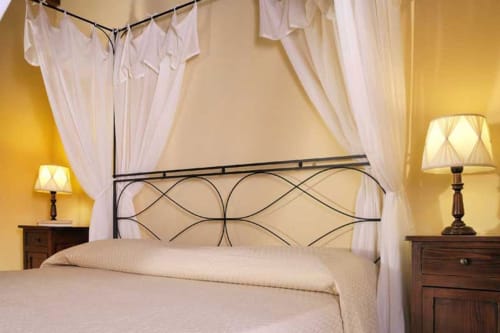 Elegante letto a baldacchino con tende bianche presso la Lodole Country House a Monzuno, Italia