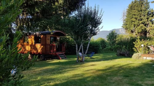 Wooden gypsy caravan at La Jument Verte B&B in Trévignin, France, set on green lawn with mountain views