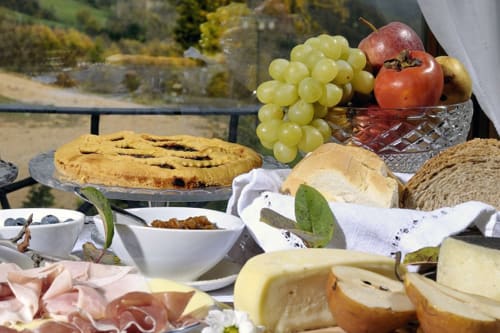Deliziosa merenda in campagna presso Lodole Country House con uva, pomodoro, formaggi, pane e salumi con vista panoramica
