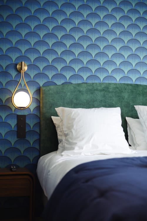 Chambre élégante L'Ode à Pierre avec tête de lit verte, oreillers blancs, papier peint bleu ondulé et suspension dorée à Dax