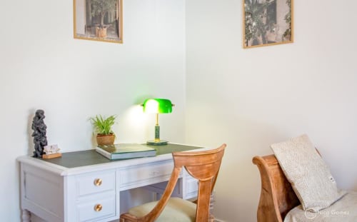 Espace de travail élégant à la Suite du Pacte Secret du Mas De La Clé D'Or, avec un bureau blanc, une lampe verte et du bois