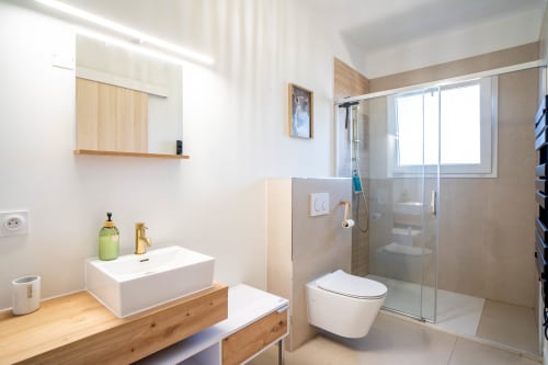 Salle de bains moderne de la suite Le Mas De La Clé D'Or avec douche à l'italienne, vasque suspendue et vue sur le jardin à Puget sur Argens