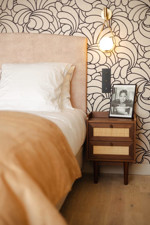 Chambre douillette à L'Ode à Pierre B&B à Dax avec papier peint à motifs, table de nuit rétro et lampe dorée