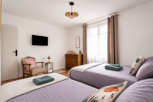 Suite spacieuse pour 5 personnes au Mas De La Clé D'Or : deux lits, mobilier en bois, TV et décoration élégante